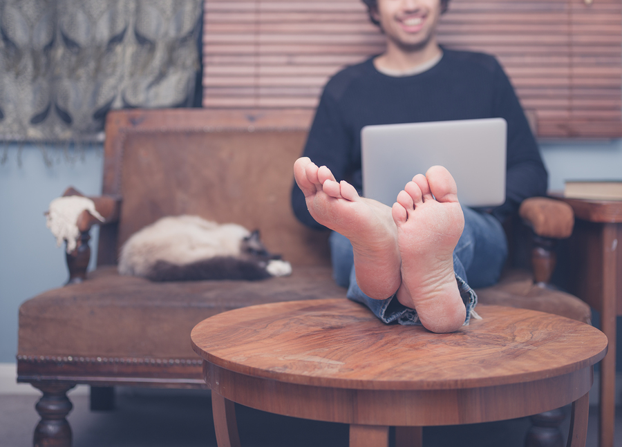 Barefoot Man Working On Laptop