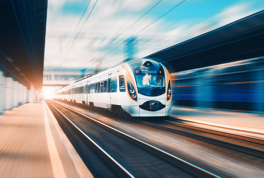 A speeding passenger train leaving a station