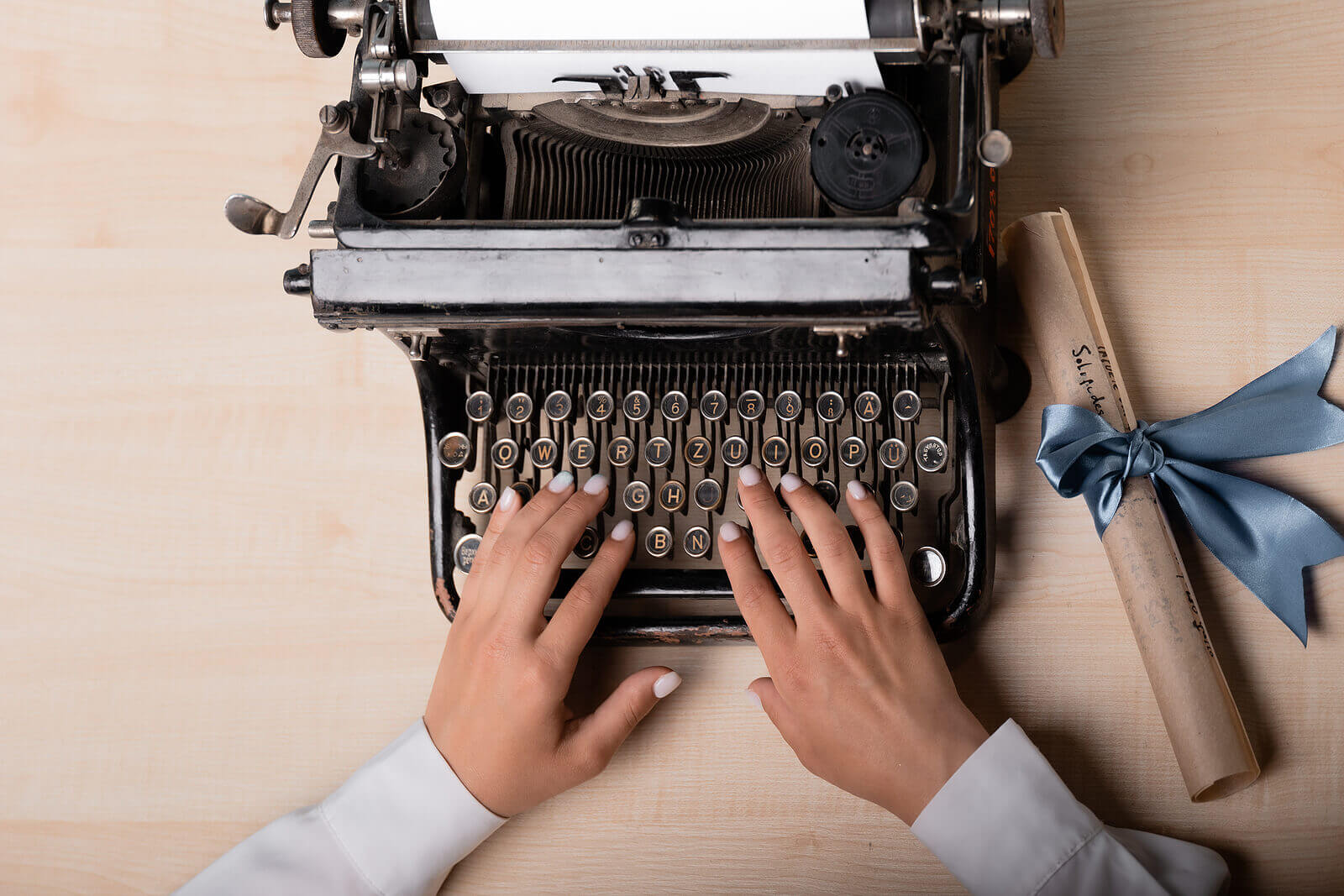 A lady types on a typwriter.