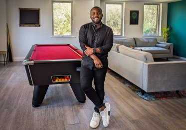 Thierry stands in front of a pool table in the SALT kitchen